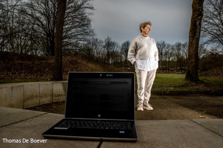 Els De Mey van Het Gielsbos staat voor een laptop in het bos.